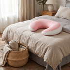 Adjustable pregnancy pillow styled on a made bed in a calm, softly lit bedroom